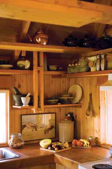 Open shelving is built into the walls' structure. Denise enjoys light from the south, west and north as she cooks.